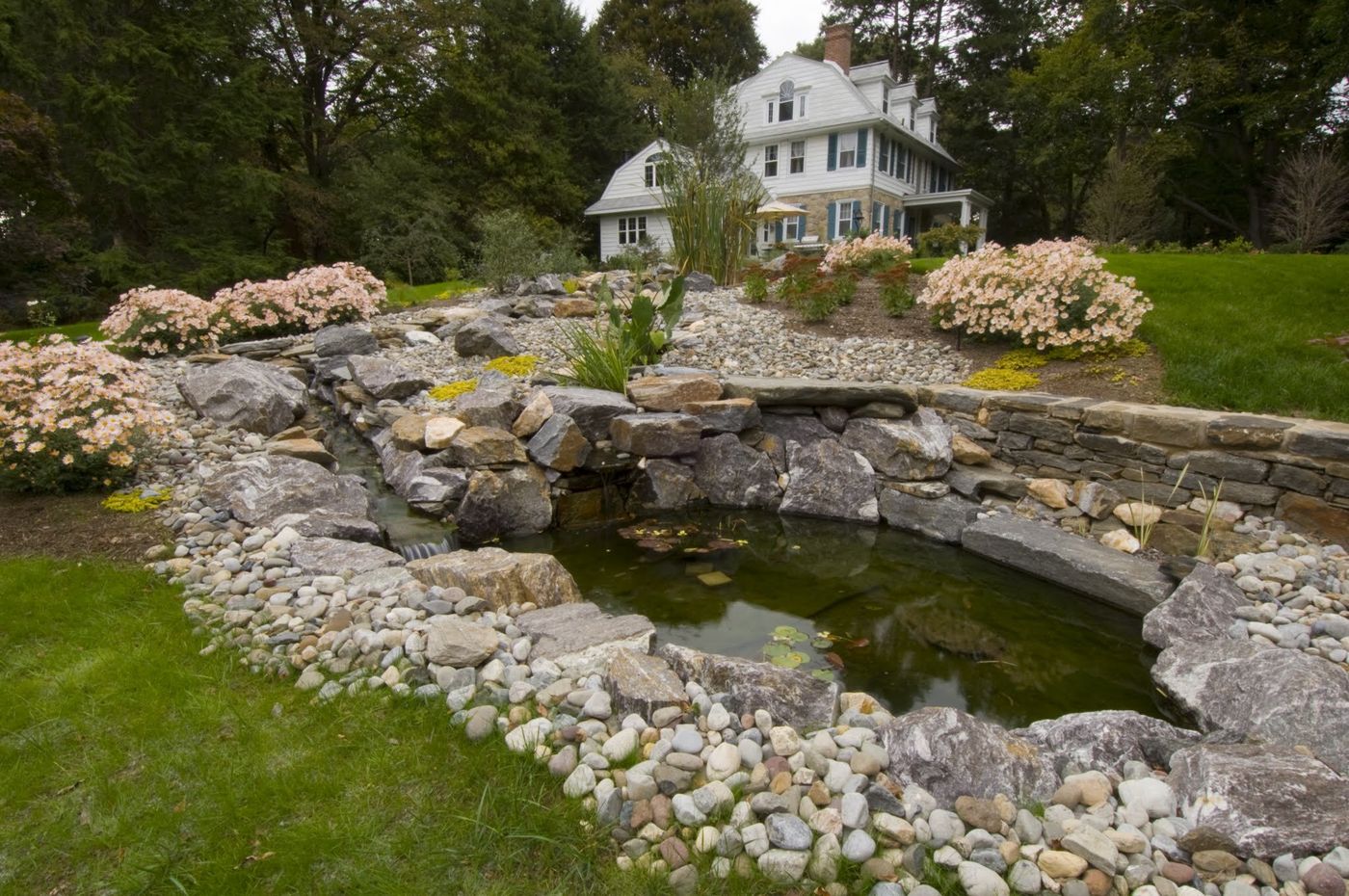 Natural stone pond and water feature set into an estate lawn